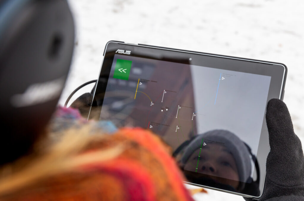 Someone walking around the Enerhaugen neighborhood, with the Torn Tracks: Enerhaugen work on a tablet